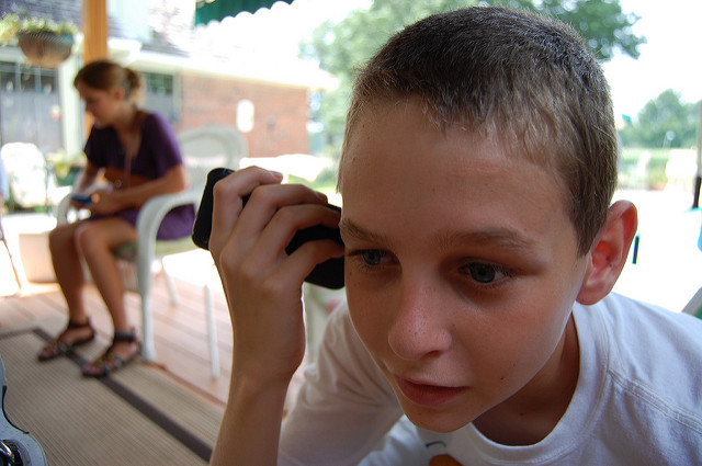 A child listening to an iPhone's speaker